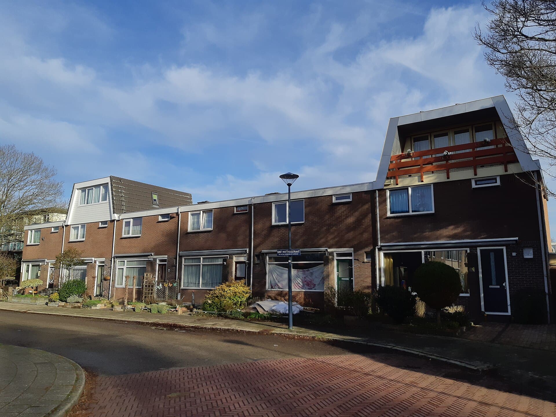 Rij rijtjeshuizen in de Sint Matthijsstraat in Hoorn met een dakkapel en een nokverhoging met balkon